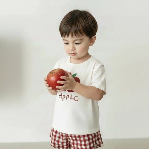 Two-piece children's outfit with white shirt and red checkered shorts on a hanger.