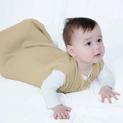 Baby wearing a beige sleeping bag on a white background, with 'Insular' branding.